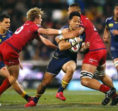 Christian Lealiifano of the Brumbies is tackled by the Reds
